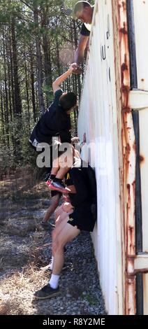 Soldats grimper sur les contenants d'expédition au défi spartiate au camp Shelby, à Hattiesburg, Mississippi, le 4 mars 2017. Le troisième événement du défi, les équipes devaient prendre leur équipement sur les conteneurs, deux portées, deux récipients d'eau de 5 gallons, un pneu de tracteur, et de la corde. (La Garde nationale du Mississippi Banque D'Images