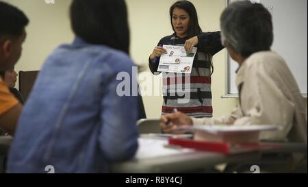 Michelle équestre, épouse du sergent-chef. Anthony équestre, enseigne pendant les Okinawaïens Schwab à la classe intermédiaire en anglais Education Centre à Camp Schwab, Okinawa, Japon, le 4 mars 2017. Le Centre de l'éducation anime une émission classe d'anglais de niveau débutant et intermédiaire le mercredi pour renforcer le lien entre les membres du service et Okinawaïens. L'Caminas, de San Antonio, Texas, également demander à l'Kin-Hansen l'amitié, à la classe d'anglais Town Central Kin Centre communautaire, Okinawa, chaque mardi. Banque D'Images