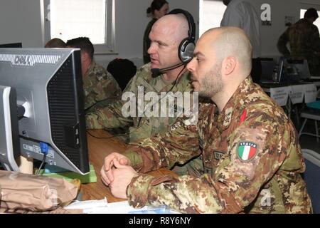 Grafenwoehr, Allemagne (3 mars 2017) - Master Sgt. William W. Reed, le directeur des incendies pour le détachement de liaison numérique 2500 à Vicenza, Italie, montre Cpt. Ivan D'Alessio, un officier dans la Brigade d'artillerie, les capacités du poste de commandement de l'avenir du logiciel. Les deux soldats de l'Armée de travailler aux côtés de l'Artillerie lituanienne centre des opérations tactiques du bataillon ici au cours de l'effort avant dynamique II. Avant dynamique II est un exercice d'exploitabilité de l'artillerie ayant lieu à la 7e armée du Commandement de l'aire d'entraînement Grafenwoehr, Allemagne, le 26 février au 10 mars 2017. Banque D'Images