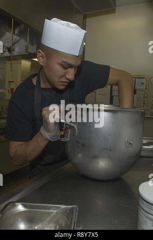 Le Corps des Marines des États-Unis. Gavinn Castillo, spécialiste de l'alimentation, 1 Division de marines, les mixer ensemble un plat pour l'équipe culinaire du trimestre à la concurrence 41 salon salle à Camp Pendleton, Californie, le 8 mars 2017. Banque D'Images