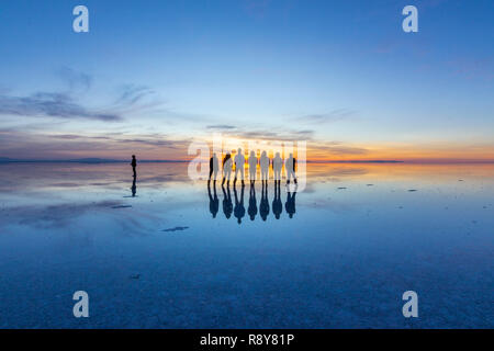 Les gens réflexions à Uyuni saltflats. L'une des plus belles choses qu'un photographe peut voir. Le lever du soleil sur un horizon infini à Uyuni Banque D'Images