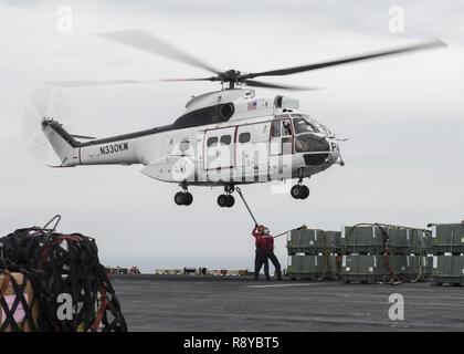 U.S. 5ÈME ZONE DES OPÉRATIONS DE LA FLOTTE (11 mars 2017) l'Aviation Ordnanceman Jaymes Cudjo, de Harker Heights, Texas, et de l'Aviation 2e classe Ordnanceman Dillon Hays, de Kansas City, Mo., fixer des fournitures à un SA-330J hélicoptère Puma à bord du navire d'assaut amphibie USS Makin Island (DG 8) lors d'un ravitaillement vertical. Makin Island est déployée dans la zone 5e flotte américaine des opérations à l'appui d'opérations de sécurité maritime visant à rassurer les alliés et les partenaires, et de préserver la liberté de navigation et la libre circulation du commerce dans la région. Banque D'Images