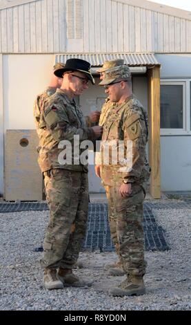 Le brig. Le général D. A. Sims, Groupe de travail Forge commandant, le Lieutenant-colonel Michael Grundman donne Garde nationale d'armée, 38e Division d'infanterie, commandant une division de cavalerie au cours d'un combat patch patch cérémonie dans la province de Helmand, Afghanistan, le 10 mars 2017. Grundman mène 46 gardes nationaux de l'Indiana, Ohio, Kentucky, Maryland, Michigan et Ohio qui ont appuyé l'opération Liberté's Sentinel en théâtre pour 30 jours. (L'OTAN Banque D'Images