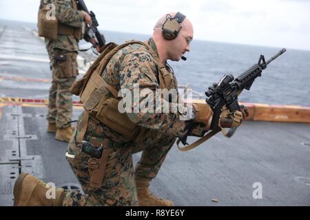 U.S. Marine Corps, l'Adjudant-chef 2 Steven Tamm, agent responsable des explosifs et munitions (NEM), du bataillon logistique de combat de section 31, 31e Marine Expeditionary Unit (MEU), effectue des procédures d'assainissement sur une carabine M4 au cours d'un tournage de pont à bord du USS Bonhomme Richard (DG 6), dans l'océan Pacifique, le 14 mars 2017. Marines avec bec-31, 31e MEU fait l'objet d'entraînement au tir de combat dans le cadre de la 31e MEU 17.1 La patrouille de printemps de la région Asie-Pacifique. Comme le Corps des Marines' seulement continuellement de l'avant de l'unité déployée, la 31e MEU's air-sol-logistique équipe offre une f Banque D'Images