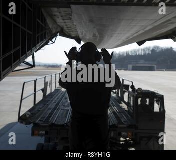 Airman Senior Elias Wilson, 22e Escadron de transport aérien, marshals dans une K-chargeur pour décharger la cargaison après l'atterrissage à Base aérienne Osan, en Corée du Sud, le 7 mars 2017. Près de 70 000 livres de marchandises ont été déchargées à Osan AB. Banque D'Images