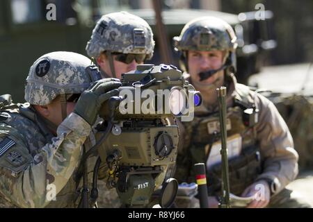 Un feu de l'armée américaine spécialiste des contrôles avec la 101st Airborne Division (Air Assault) utilise un télémètre désignateur laser léger 2H pour fournir un appui-feu acquisition d'objectifs et de reconnaissance au cours de l'appui aérien rapproché avec la formation des pilotes aux commandes d'un AH-1W Super Cobra hélicoptère de combat et d'un hélicoptère UH-1Y Venom au cours de l'exercice guerrier 78-17-01 le 17 mars, 2017 at Joint Base McGuire-Dix-Lakehurst. Contrôles d'incendie affectés au siège de spécialiste et le Siège Batterie, 3e Bataillon, 320e Régiment d'artillerie, avec la direction de la Société A (Société simple), 2e Batt Banque D'Images