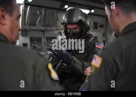 Le Capitaine Jason Carroll, 15e Escadron de transport aérien pilote instructeur d'airdrop avant un vol à l'aérodrome auxiliaire en Amérique du Nord, Caroline du Sud, le 15 mars 2017 pour l'exécution de la formation en vol avec l'œil de l'équipage et du système de protection respiratoire (AERPS) de l'équipement. Le vol, pour la première fois en plus de 10 ans où des équipages d'AERPS portaient l'équipement. AERPS équipement consiste en un masque de caoutchouc, de multiples couches de bottes et de gants, filtre de ventilateur et système audio et un système d'enceintes. Banque D'Images