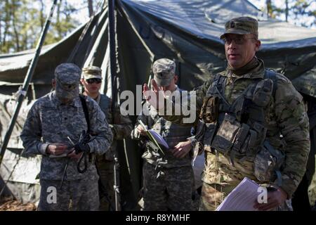 Réserve de l'armée américaine observer/contrôleur formateur, affecté à la 78e Division de la formation, effectue l'examen après action de l'armée américaine avec des soldats de réserve affecté à la Compagnie de la Police militaire de la 423rd, 333e Brigade de police militaire, la Police militaire 200e commande, le 19 mars 2017, à McGuire-Dix-Lakehurst, New Jersey. L'unité de police militaire a travaillé avec l'US Air Force 621e Escadre le Plan d'intervention et de l'US Air Force Reserve 732e Escadron de transport aérien pour effectuer une mission de transport aérien mixte au cours de l'exercice guerrier 78-17-01, qui vise à évaluer les capacités de combat de l'unité. Environ 60 unités de th Banque D'Images