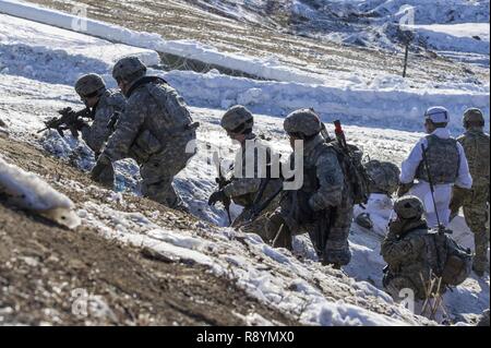 Affecté à une compagnie de parachutistes, 6e bataillon du génie de la Brigade d'infanterie, 4e Brigade Combat Team (Airborne), 25e Division d'infanterie de l'armée américaine, l'Alaska, se déplacer à enfreindre une fil de fer barbelés lors d'entraînement au tir réel au peloton d'infanterie Battle Course sur Joint Base Elmendorf-Richardson, Alaska, le 17 mars 2017. L'exercice aiguisé les parachutistes de l'infanterie des compétences telles que la communication et le mouvement de peloton, obstacle violer et la capture d'un objectif intermédiaire de voies de fait et de manœuvre. Banque D'Images