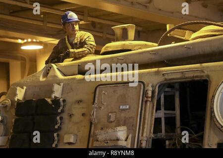 La CPS. Julian Chamu, un réparateur de véhicule de piste avec 2e Bataillon, 7e régiment de cavalerie indigène et de Santa Anna, Californie, attend d'autres instructions de la part des soldats de la 936e élément d'exploitation Terminal expéditionnaire, tandis qu'à bord de la de la coque du grand, vitesse moyenne, roll on roll off véhicule cargo ship USNS Brittin (T-AKR-305), au port de Shuaiba, le Koweït, le 13 mars Banque D'Images