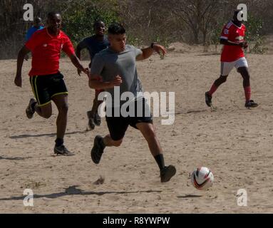 Le sergent de l'armée américaine. Christopher Punzo conserve le ballon loin de l'autre équipe pendant la partie de football organisées par les membres de la marine canadienne à Manda Bay, au Kenya, le 8 mars 2017. Après un jeu brutal, le Kenya a battu la Compagnie Bravo avec un score final de 3-1. Banque D'Images