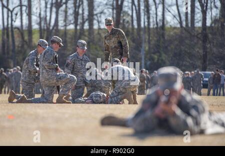 Une équipe de l'Université Clemson Corps de formation des officiers de réserve de l'évaluation de la pratique et de l'extraction de cadets un blessé alors que la Garde nationale de l'armée américaine de la CPS. John Douglas, un infirmier de la 4e Bn., 118e Régiment d'infanterie (debout) les évalue au cours d'un exercice chronométré sur le campus de Clemson, le 16 mars 2017. Banque D'Images