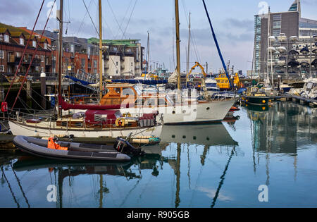 Les quais de carrossage à Portsmouth avec appartements tout autour et la location de bateaux de plaisance entre les bateaux de pêche commerciale Banque D'Images