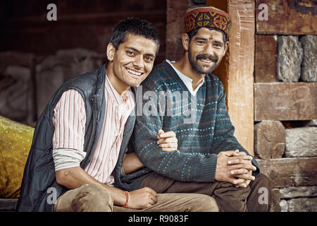 Naggar, Inde - août 2017. Deux indiens traditionnels mens sit près de la chambre, regarder et sourire à l'appareil photo. Naggar, Himachal Pradesh. L'Inde du Nord. Banque D'Images