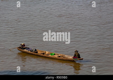 Thakhek, Laos - 19 Avril 2018 : homme assis sur son bateau à la pêche dans la rivière du Mékong boueux au Laos, au lever du soleil près de la frontière thaïlandais Banque D'Images