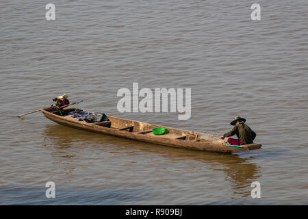 Thakhek, Laos - 19 Avril 2018 : homme assis sur son bateau à la pêche dans la rivière du Mékong boueux au Laos, au lever du soleil près de la frontière thaïlandais Banque D'Images