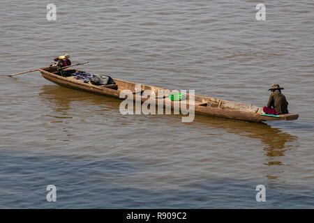 Thakhek, Laos - 19 Avril 2018 : homme assis sur son bateau à la pêche dans la rivière du Mékong boueux au Laos, au lever du soleil près de la frontière thaïlandais Banque D'Images