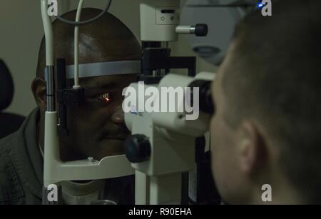 Le Major de l'US Air Force, le 35e Woodbury Ethan médecine aérospatiale, commandant de l'escadrille de l'Escadron l'optométrie utilise une lampe à fente d'examiner un patient's eyes à Misawa Air Base, Japon, le 9 mars 2017. Lampes à fente déterminer une santé oculaire du patient par l'examen de domaines, y compris les paupières, cornée et l'iris. La 35e FW's foundation est les gens et faire en sorte d'aviateurs sont prêts à exécuter la mission du Pacifique de la stabilité et de la sécurité en tout temps et la clinique d'Optométrie de Misawa fait justement cela. Banque D'Images