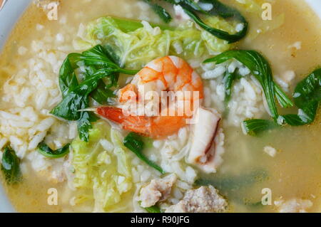 Riz bouilli avec des fruits de mer dans un bol de soupe sur Banque D'Images