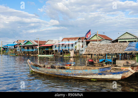 Vieux bateau en bois et maisons traditionnelles sur pilotis au village de pêcheurs flottant dans le lac Tonle Sap. Kampong Phluk, province de Siem Reap, Cambodge, Asie Banque D'Images