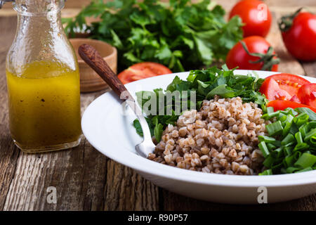 Le sarrasin cuit sain salade de céréales avec des oignons verts, le persil et les tomates, l'huile d'olive et le jus de citron, vinaigrette d'aliments à base de plantes, foc sélective Banque D'Images