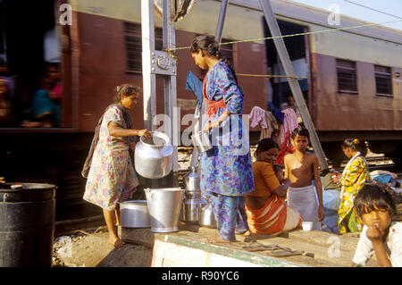 Taudis près de la voie ferrée, les femmes collectent de l'eau, ligne portuaire, bombay, mumbai, maharashtra, Inde, asie Banque D'Images