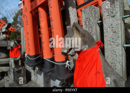 Les renards de pierre gardien au Sanctuaire Fushimi Inari Taisha, Inari, Kyoto, Japon. Banque D'Images