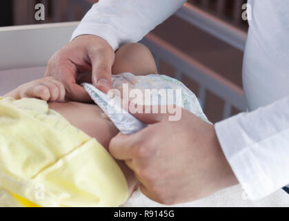 Jeune papa change la couche et les vêtements pour son petit enfant nouveau-né. Selective focus Banque D'Images