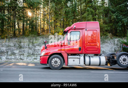 Transport de marchandises par camions semi en Amérique - le type principal de la logistique. Big Rig semi truck rouge avec un chargement sur les semi-remorques à plateau tournant sur highw Banque D'Images