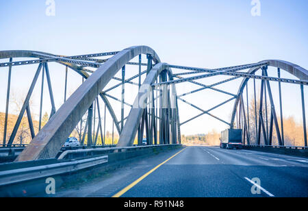 Gros camion semi long haul truck transport remorque semi couverte avec du fret commercial de la conduite sur l'hiver frosty arqua truss bridge avec connecte Banque D'Images