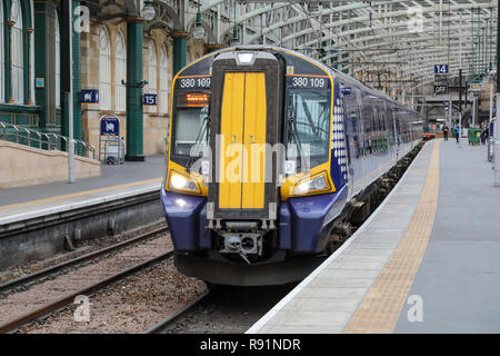 Un train électrique de Classe 380 Scotrail au départ de 14 plate-forme de la gare centrale de Glasgow. Banque D'Images