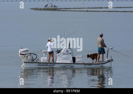 Un couple sur un bateau de pêche avec leur chien. Aransas National Wildlife Refuge, Texas, USA. Banque D'Images