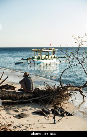 Pêcheur en attente à son bateau à Gili Kondo, une petite île de Lombok. Banque D'Images