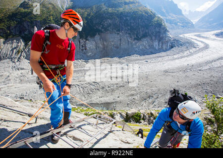 Les grimpeurs descendre des échelles menant vers le bas sur la mer de glace près de la gare du Montenvers. La ligne fut construite à l'époque victorienne pour prendre les touristes jusqu'au glacier, il a par la suite du 150 mètres depuis 1820, et se retira en 2300 mètres. Afin d'accéder au glacier vous avez maintenant de descendre plus de 100 mètres sur des échelles. Banque D'Images