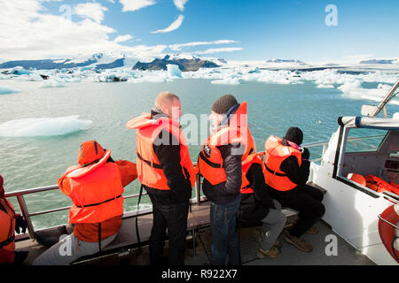 Circonscription tourisme dans un camion amphibie à la lagune glaciaire du Jökulsárlón, un des endroits les plus visités de l'Islande. Il a été créé par la régression rapide du glacier Breidamerkurjokull qui balaie en bas de la calotte glaciaire de Vatnajokull. Ice bergs mettent bas à l'avant et flotter dans le lagon avant de flotter sur la mer quand assez petit. Tous les glaciers reculent rapidement, et sont prévus pour disparaitre complètement dans les 100 prochaines années. Les films Batman et James Bond ont été filmés à la lagune de glace. Banque D'Images