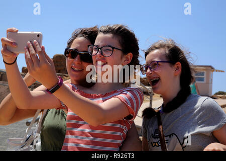 Attica Grèce Cap Sounion, la mère et les filles en tenant avec Smartphone Selfies Banque D'Images