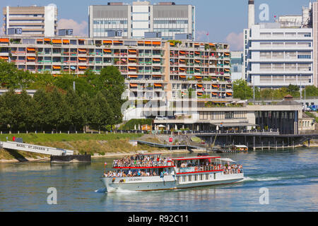 Les bâtiments de la ville de Bâle le long du Rhin, le bateau Lallekonig avec passagers à bord en passant Banque D'Images