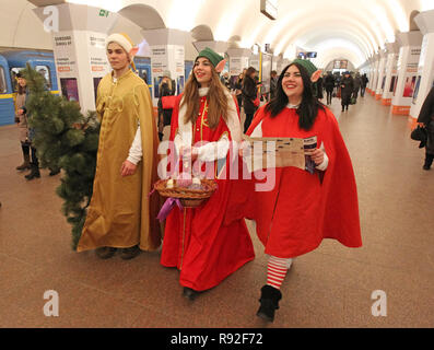 18 décembre 2018 - Kiev, Kiev, Ukraine - portant les costumes de lutins de Noël vu marcher à l'intérieur du métro de Kiev à Kiev, Ukraine..la procession de fête de Noël elfes vont a commencé à Kiev. Santa helpers lumineux se sont réunis pour annoncer le début de ce Noël et d'ouvrir la résidence féerique du Père Noël dans le oeGallery Laurusâ des Arts de€. Elfes élégant parcouru à pied, et a également visité le métro de Moscou pour créer une ambiance de fête pour tout le monde. (Crédit Image : © Pavlo Gonchar/SOPA des images à l'aide de Zuma sur le fil) Banque D'Images