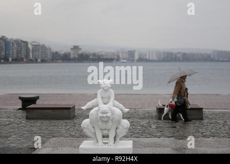 Thessalonique, Grèce. Dec 18, 2018. Une femme passe devant une sculpture de l'artiste chinois Xu Hongfei au port de Thessalonique, en Grèce, le 18 décembre 2018. L'artiste chinois Xu Hongfei, président de l'Académie de Sculpture de Guangzhou, a présenté 15 de ses sculptures de personnages féminins à la ville portuaire de Thessalonique dans le nord de la Grèce, dans le cadre d'une tournée mondiale de son exposition. Credit : Dimitris Tosidis/Xinhua/Alamy Live News Banque D'Images