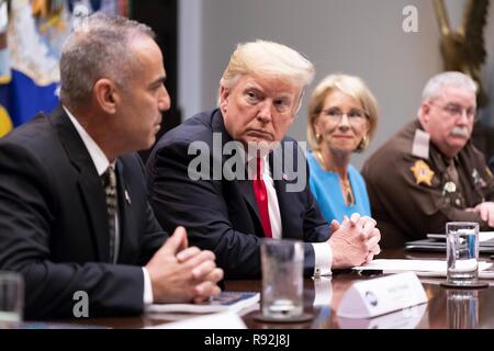 Washington DC, USA. Au 18 décembre 2018. Le Président américain Donald Trump, centre, à l'écoute de Andy Pollack, le père d'une école secondaire Marjory Stoneman Douglas victime, gauche, au cours d'une réunion sur la sécurité à l'école rapport, dans la Roosevelt Room de la Maison Blanche, 18 décembre 2018 à Washington, DC. Credit : Planetpix/Alamy Live News Banque D'Images