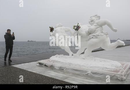 Beijing, la Grèce. Dec 18, 2018. Un homme prend des photos d'une sculpture de l'artiste chinois Xu Hongfei au port de Thessalonique, en Grèce, le 18 décembre 2018. Xu Hongfei, président de l'Académie de Sculpture de Guangzhou, a présenté 15 de ses sculptures de personnages féminins à Thessalonique, dans le cadre d'une tournée mondiale de son exposition. Credit : Dimitris Tosidis/Xinhua/Alamy Live News Banque D'Images