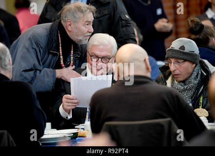 19 décembre 2018, Berlin : Président fédéral Frank-Walter STEINMEIER (SPD) centre l, parle à l'indigent à la table. Le président fédéral visite le réchauffement de la pièce de la Berliner Kältehilfe dans la Heilig-Kreuz-Kirche. Photo : Britta Pedersen/dpa-Zentralbild/dpa Banque D'Images