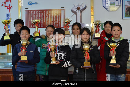 Xiema, Chine. Dec 19, 2018. Les étudiants démontrent des trophées de l'équipe de soccer à l'École centrale en ville Xiema Xiema Canton de Baokang, comté de la province du Hubei en Chine centrale, 18 décembre 2018. Ville Xiema Central School, un pensionnat rural situé dans la région montagneuse de la province du Hubei, est le premier pilote vedette de soccer school de Baokang. L'école construit un terrain de football en 2015, et ajouté à son programme de soccer, en fournissant aux étudiants un accès à plus de chances de jouer au soccer, ainsi que pour aider les jeunes footballeurs poursuivre leurs rêves. (Xinhua/Yang Tao) Credit : Xinhua/Alamy Vivre sw Banque D'Images