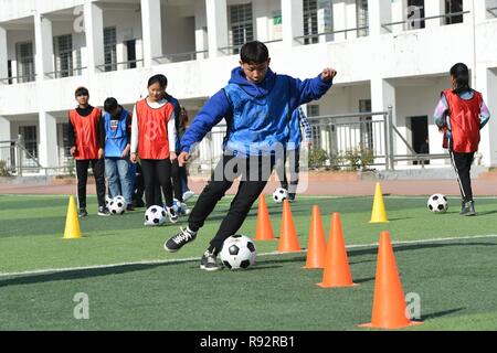 Xiema, Chine. Dec 19, 2018. Les étudiants mettent en pratique les compétences de soccer à l'École centrale en ville Xiema Xiema Canton de Baokang, comté de la province du Hubei en Chine centrale, 18 décembre 2018. Ville Xiema Central School, un pensionnat rural situé dans la région montagneuse de la province du Hubei, est le premier pilote vedette de soccer school de Baokang. L'école construit un terrain de football en 2015, et ajouté à son programme de soccer, en fournissant aux étudiants un accès à plus de chances de jouer au soccer, ainsi que pour aider les jeunes footballeurs poursuivre leurs rêves. (Xinhua/Yang Tao) Credit : Xinhua/Alamy Live News Banque D'Images