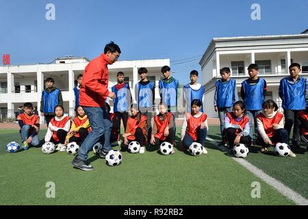 Xiema, Chine. Dec 19, 2018. Zheng Yu instructeur de football soccer démontre à Xiema Town Central School à Xiema Canton de Baokang, comté de la province du Hubei en Chine centrale, 18 décembre 2018. Ville Xiema Central School, un pensionnat rural situé dans la région montagneuse de la province du Hubei, est le premier pilote vedette de soccer school de Baokang. L'école construit un terrain de football en 2015, et ajouté à son programme de soccer, en fournissant aux étudiants un accès à plus de chances de jouer au soccer, ainsi que pour aider les jeunes footballeurs poursuivre leurs rêves. (Xinhua/Yang Ta Crédit : Xinhua/Ala Banque D'Images