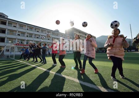 Xiema, Chine. Dec 19, 2018. Les étudiants mettent en pratique les compétences de soccer à l'École centrale en ville Xiema Xiema Canton de Baokang, comté de la province du Hubei en Chine centrale, 18 décembre 2018. Ville Xiema Central School, un pensionnat rural situé dans la région montagneuse de la province du Hubei, est le premier pilote vedette de soccer school de Baokang. L'école construit un terrain de football en 2015, et ajouté à son programme de soccer, en fournissant aux étudiants un accès à plus de chances de jouer au soccer, ainsi que pour aider les jeunes footballeurs poursuivre leurs rêves. (Xinhua/Yang Tao) Credit : Xinhua/Alamy Live News Banque D'Images