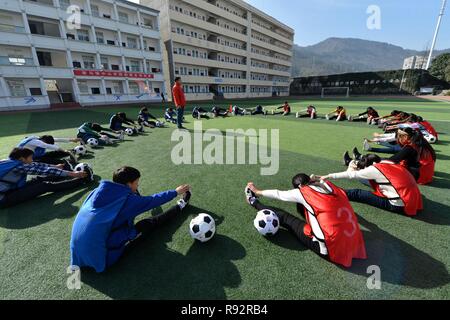 Xiema, Chine. Dec 19, 2018. Assouplir les élèves sur une classe de soccer à l'École centrale en ville Xiema Xiema Canton de Baokang, comté de la province du Hubei en Chine centrale, 18 décembre 2018. Ville Xiema Central School, un pensionnat rural situé dans la région montagneuse de la province du Hubei, est le premier pilote vedette de soccer school de Baokang. L'école construit un terrain de football en 2015, et ajouté à son programme de soccer, en fournissant aux étudiants un accès à plus de chances de jouer au soccer, ainsi que pour aider les jeunes footballeurs poursuivre leurs rêves. (Xinhua/Yang Tao) Credit : Xinhua/Alamy Live News Banque D'Images