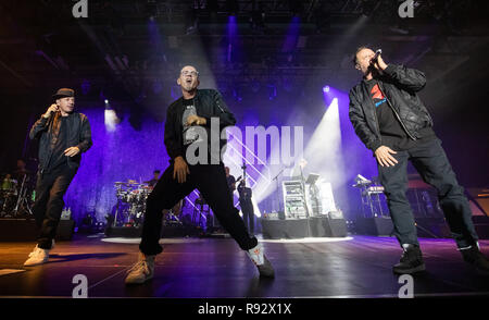 19 décembre 2018, la Bavière, Würzburg : Michael 'Michi' Beck (l-r), Michael Bernd Schmidt, alias Smudo et Thomas Dürr alias Thomas D, membres du groupe de hip-hop allemand Die Fantastischen Vier, sont sur la scène du concert d'ouverture de la 'capitaine' tour fantastique. Photo : Daniel Karmann/dpa Banque D'Images