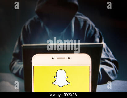 Hong Kong. 22 Nov, 2018. Application de messagerie multimédia logo SnapChat est vu sur un appareil mobile Android avec une figure de hacker dans l'arrière-plan. Credit : Miguel Candela/SOPA Images/ZUMA/Alamy Fil Live News Banque D'Images