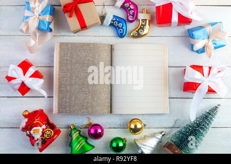 Noël ou Nouvel an composition du châssis avec blank notepad pour des rêves, projets, tâches, salutations à l'intérieur sur fond de bois clair. Mise à plat, vue du dessus, Banque D'Images